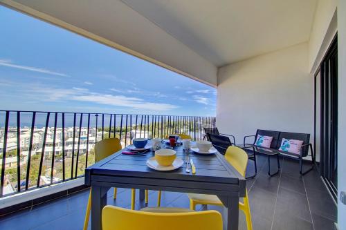 FleurimontL'appartement de l'Horizon - Plateau Cailloux的阳台的用餐室配有桌椅