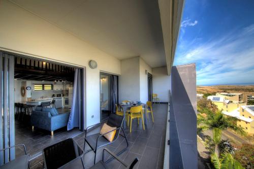 FleurimontL'appartement de l'Horizon - Plateau Cailloux的阳台享有起居和用餐室的景致。