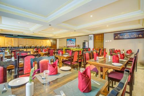 佩林Summit Tashi Ghang Heritage Resort的一间带桌椅和红色椅子的餐厅