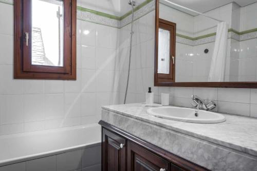 上阿兰Tanau 1700 by SeaMount Rentals的浴室配有盥洗盆、镜子和浴缸