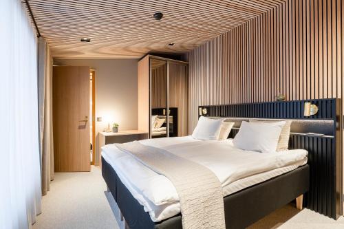罗瓦涅米Glass Resort的一间卧室配有一张带白色床单的大床