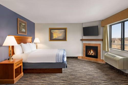拉勒米拉勒米阿美瑞辛旅馆及套房的酒店客房配有一张床和一个壁炉。