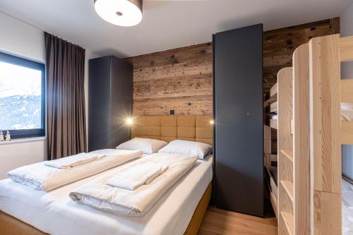 滕嫩山麓圣马丁Hideaway Dachstein West by ALPS RESORTS的一间卧室设有两张床和木墙