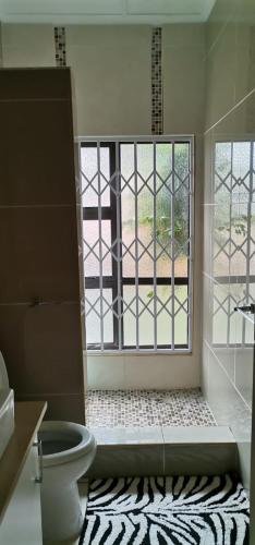 恩潘盖尼Saginix Guesthouse的一间带卫生间的浴室和大窗户