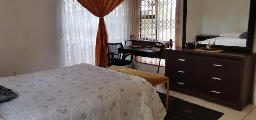 恩潘盖尼Saginix Guesthouse的一间卧室配有一张床、梳妆台和书桌