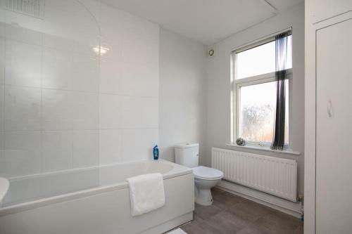 拉夫堡Cozy 3 bedroom house @ Hömli的白色的浴室设有浴缸和卫生间。