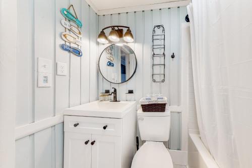 斩魔山Beach House的浴室设有白色的卫生间和镜子