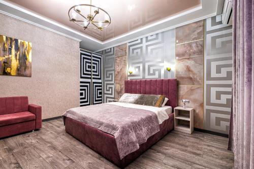 利沃夫2 - bedroom Apartments Galicia Lviv的一间卧室配有一张床和一张红色椅子
