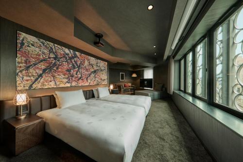 东京The Royal Park Canvas Ginza Corridor的一间卧室配有一张大床,墙上挂着一幅大画