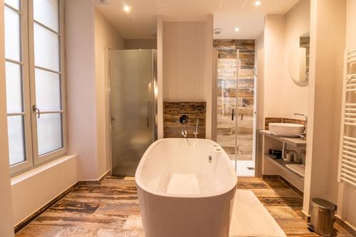 萨尔拉拉卡内达Sarlatitude, Studios & Chambres的大型浴室设有浴缸和淋浴。