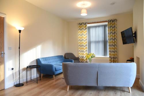赖厄德Mid Wales Holiday Lets, Rhayader的客厅设有蓝色的沙发和窗户。