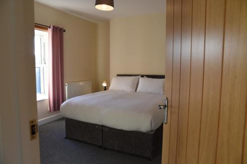 赖厄德Mid Wales Holiday Lets, Rhayader的一间卧室设有一张大床和一个窗户。