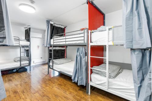多伦多Samesun Toronto的客房设有三张双层床,铺有木地板。