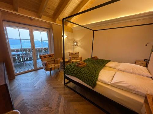 福森科索尔兰德之家酒店的一间卧室设有一张天蓬床和一个阳台
