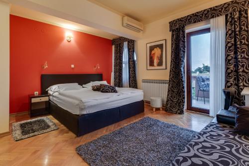 扎达尔马林可酒店的一间卧室设有一张床和红色的墙壁
