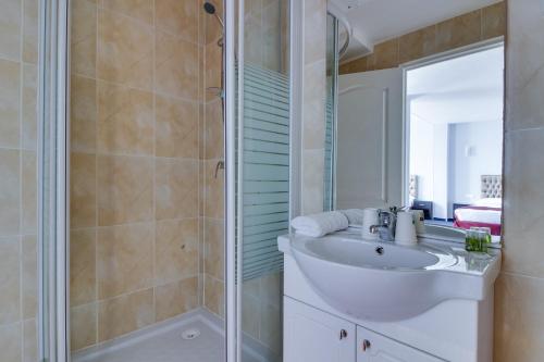 塞纳河畔伊夫里HOTEL ROYAL Paris Ivry的一间带水槽和淋浴的浴室