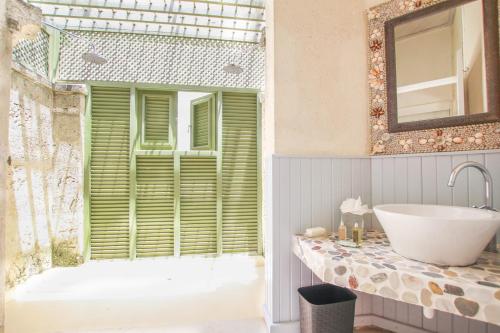 圣詹姆斯Marsh Mellow South Cottage by BSL Rentals的带浴缸、水槽和窗户的浴室
