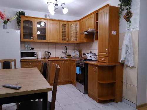 海乌姆Mieszkanie w Centrum Chełma的厨房配有木制橱柜和木桌。