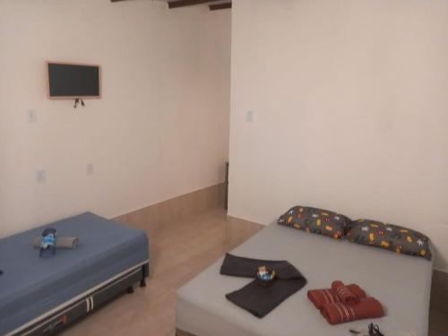 塞古罗港Na Casa da Anna的客房设有两张床和一台墙上的电视。