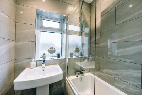 蒂斯河畔斯托克顿Wolviston House By Horizon Stays的一间带水槽和玻璃淋浴的浴室