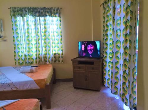 长滩岛Ocean Breeze Inn的一间带电视的梳妆台和床的房间