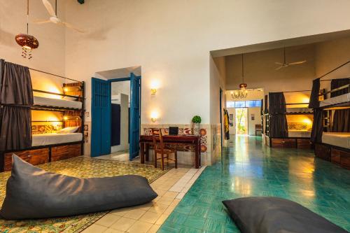 梅里达Che Nomadas Mérida Hostel Adults Only的大房间设有双层床和桌子