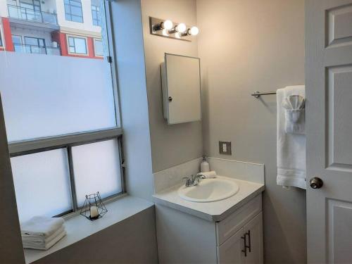 卡尔加里Modern Suite in Historic Bldg. Minutes to DT的一间带水槽和镜子的浴室以及窗户。