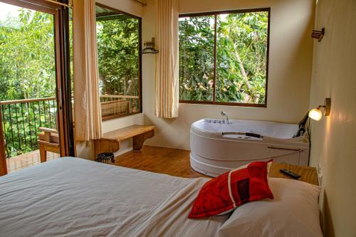 明多卡巴尼亚斯山林旅馆的一间卧室设有一张床、浴缸和一个窗口