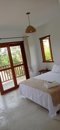 伊塔乌纳斯Pousada Aroeira的一间卧室设有一张床和一个大窗户