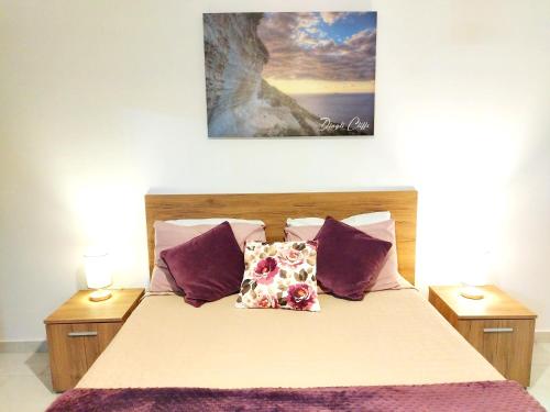 莫斯塔Stylish apartment in central Malta的一间卧室配有一张带紫色枕头的床