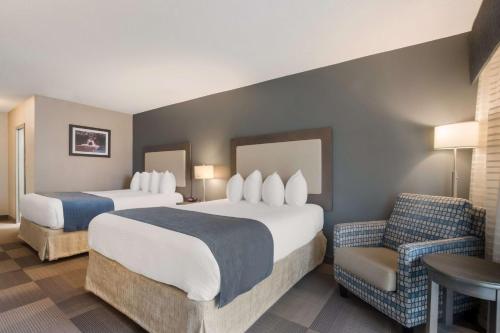 圣凯瑟琳市Best Western St Catharines Hotel & Conference Centre的酒店客房,配有两张床和椅子