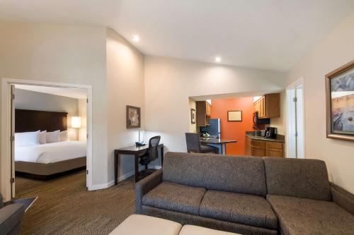 赫恩登Sonesta ES Suites Dulles Airport的客厅配有沙发和1张床