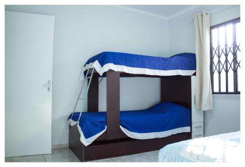 伊瓜苏Casa de Mãe - Aqui em Foz sempre cabe mais um!的一间卧室配有两张双层床,铺有蓝色床单。