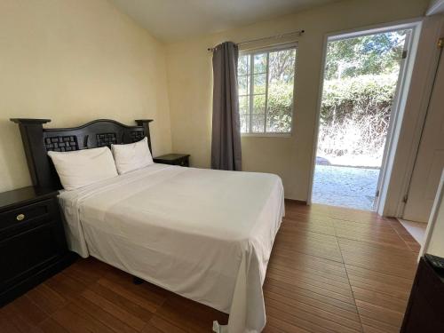 图拉德阿连德Hotel Real Home的卧室设有白色的床和大窗户