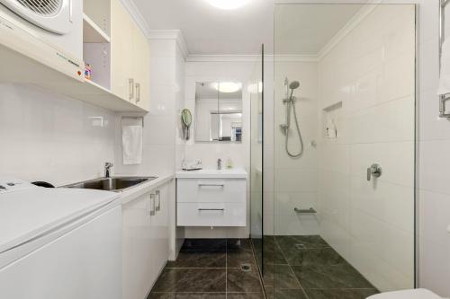 墨尔本独家公寓 - 河滨花园的白色的浴室设有水槽和淋浴。