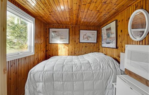OrøBeautiful Home In Or With Wifi的卧室配有木墙内的一张床
