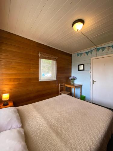巴拉斯港La Guapa Hostel的一间卧室设有一张床和木墙