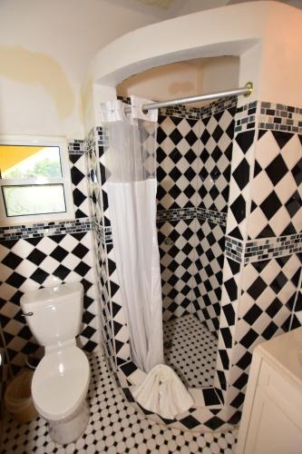 霍普金斯Harada Inn and Suites的浴室设有卫生间,铺有黑白瓷砖。