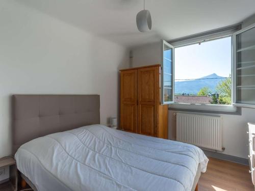 乌瑞基尼Appartement Urrugne, 5 pièces, 8 personnes - FR-1-4-493的一间卧室设有一张床和一个大窗户