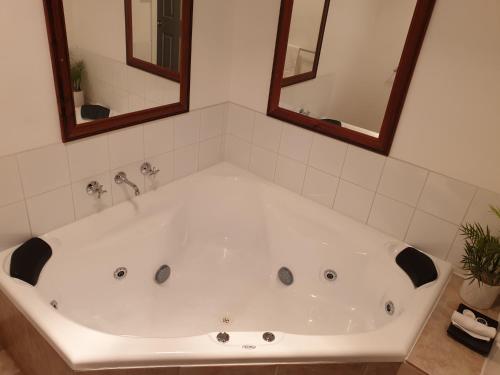 巴斯巴斯酒庄汽车旅馆的浴室设有白色浴缸,配有两面镜子