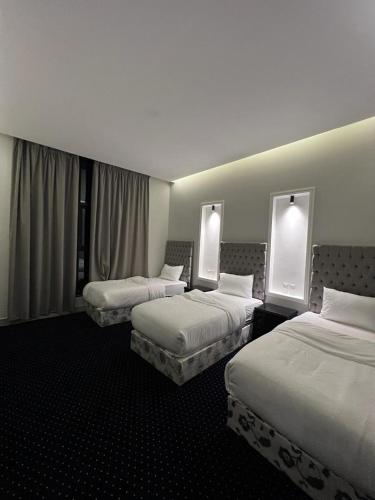 艾卜哈شاليه كريكت的酒店客房,设有三张床和两扇窗户