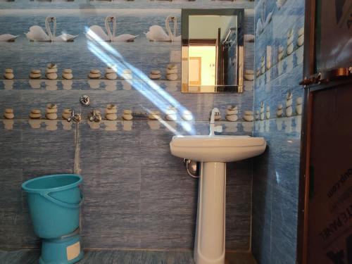 JhirnaCorbett Rejoice Home Stay的浴室设有水槽、镜子和水桶
