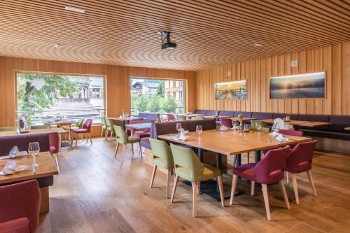 林格瑙阿德尔酒店的餐厅拥有木墙和桌椅
