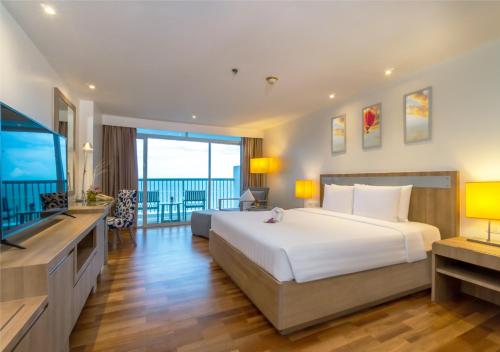 七岩Radisson Resort & Spa Hua Hin的一间卧室配有一张大床和一台平面电视