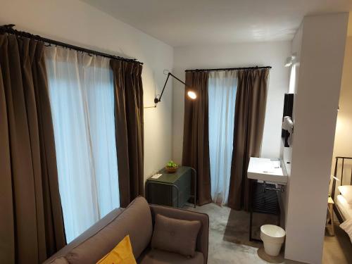 卢布尔雅那Bed & Breakfast Mozaik的客厅配有窗帘、沙发和书桌