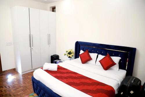 新德里Fortune Home Service Apartment 2Bhk ,E28 Saket 1A的一间卧室配有一张带红色枕头的大床
