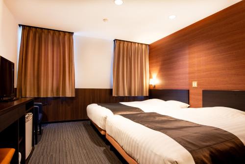 大津le Lac HOTEL Otsu Ishiyama的酒店客房设有两张床和一台平面电视。