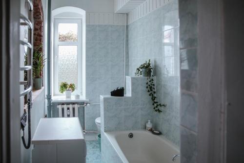 奈达Švyturio papėdė的白色的浴室设有浴缸和窗户。
