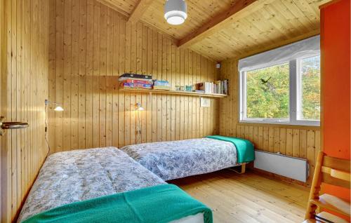 KragenæsNice Home In Fej With Kitchen的配有木墙和窗户的客房内的两张床