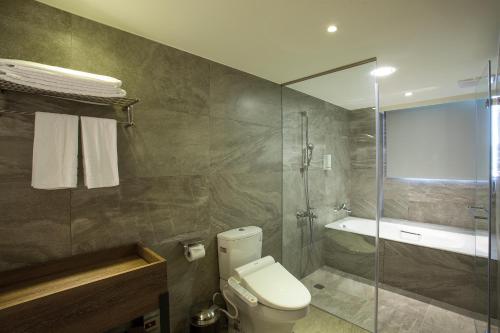 台北台北星辰大饭店的一间带卫生间和玻璃淋浴间的浴室